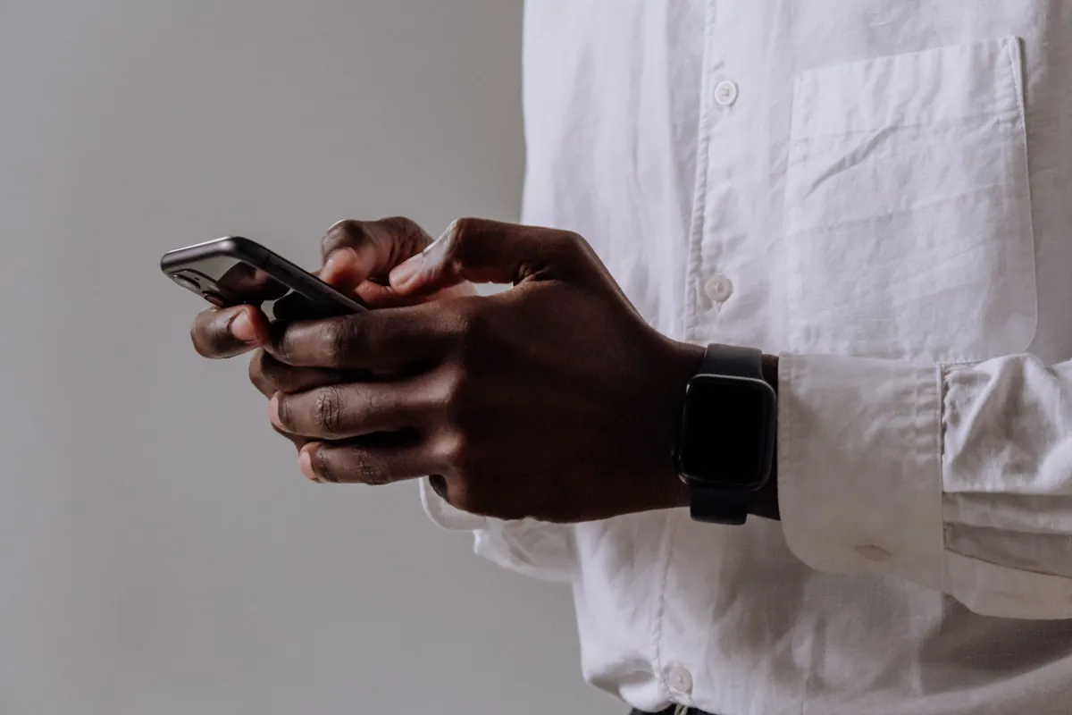 Close view of hands sending an invoice from a smartphone, the fastest way for a solo plumber to get paid after finishing a job